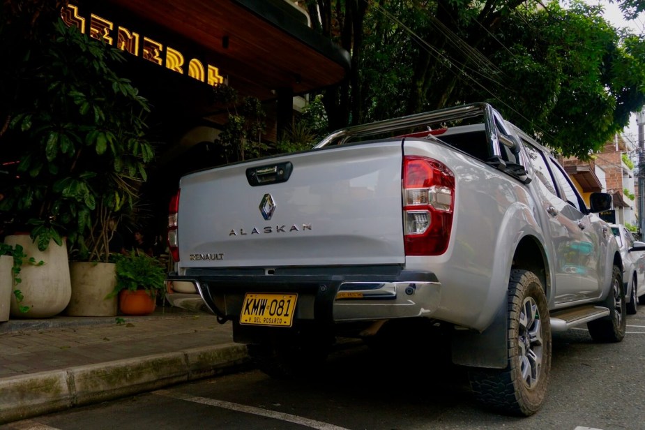 The tailgate of a Renault Alaskan pickup truck parked in Colombia, a hotel visible in the background.