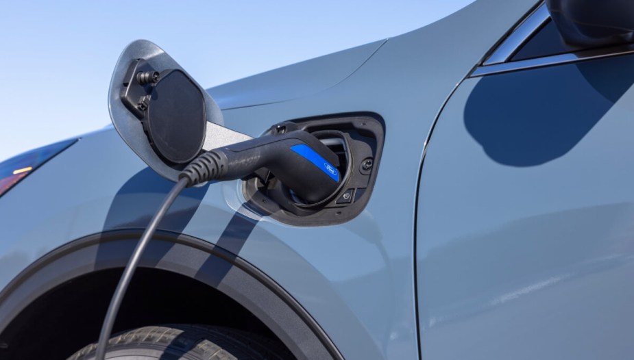 The charge port door of a plug-in hybrid Escape sits ajar as the SUV charges.