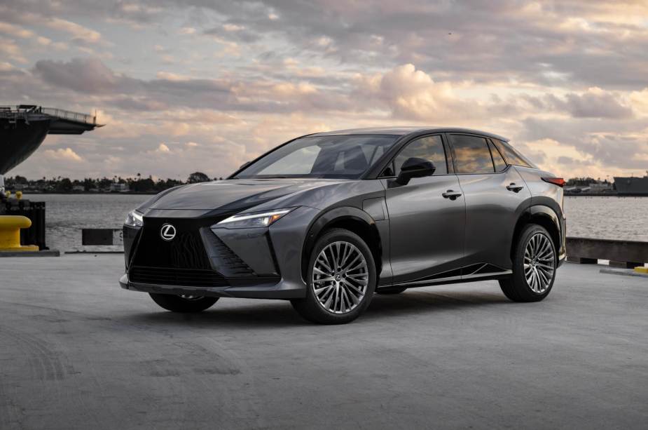 A new 2023 Lexus RZ 450e electric SUV poses with an overcast sky.
