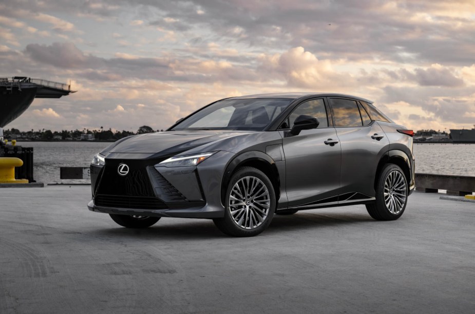 A new 2023 Lexus RZ 450e electric SUV poses with an overcast sky.