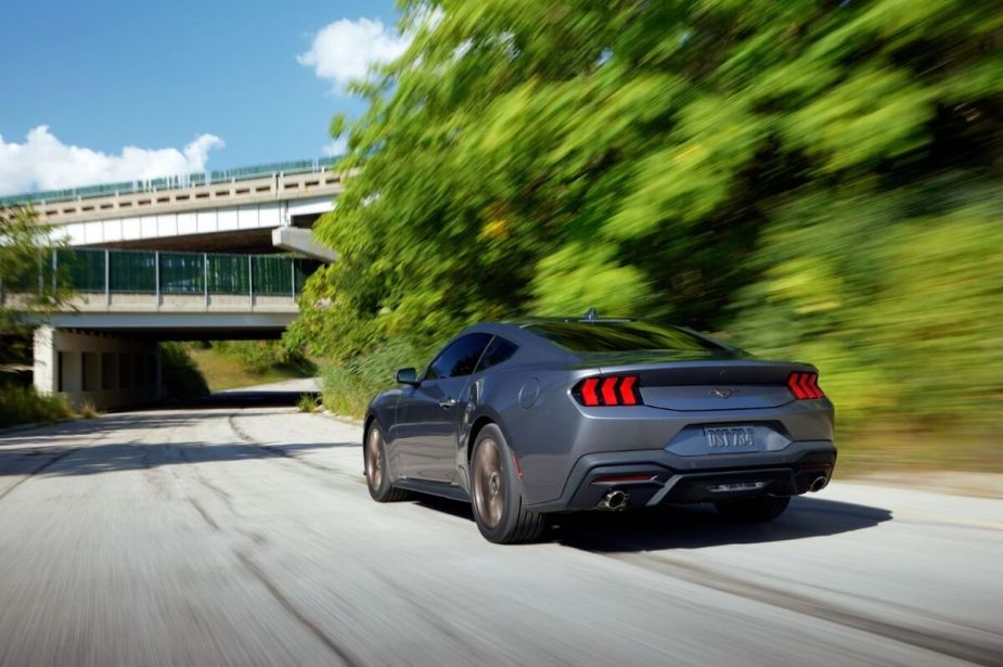 A 2024 Ford Mustang EcoBoost Premium cruises a park road.