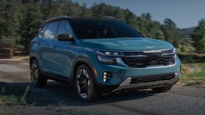 A blue 2024 Kia Seltos subcompact SUV is parked.