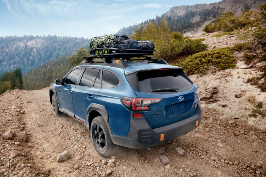 2024 Subaru Outback Wilderness prepares to descend a muddy hill off-road.