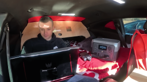 The Camaro Camper owner working on his laptop in the car.