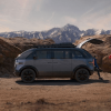 The 2023 Canoo Lifestyle Van is one of the coolest EVs qquickly approaching production. This one is parked inthe desert while people work on setting up camp.