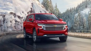 A red 2023 Chevrolet Suburban is driving.