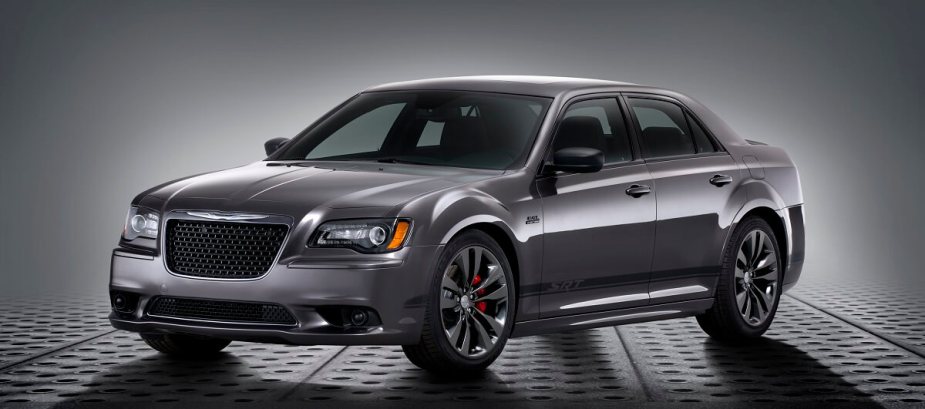 A dark-gray 2012 Chrysler 300 SRT8 shows off its luxury lines on a photo shoot stage. 