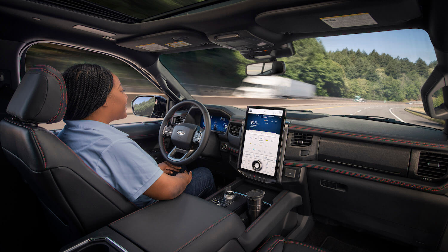 A woman demonstrates the F-150's bluecruise feature, an integral part of Ford's self repo patent.
