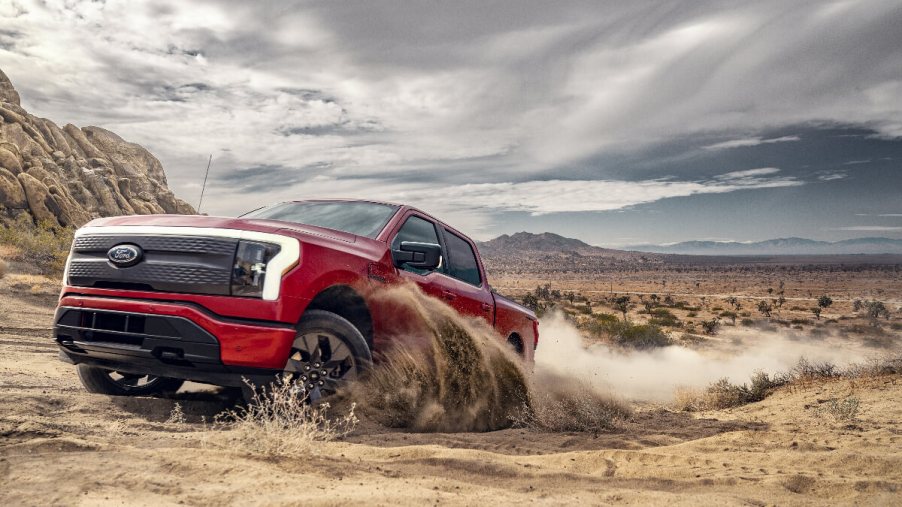 A 2023 Ford F-150 Lightning drives through dirt, this electric truck has an active recall.
