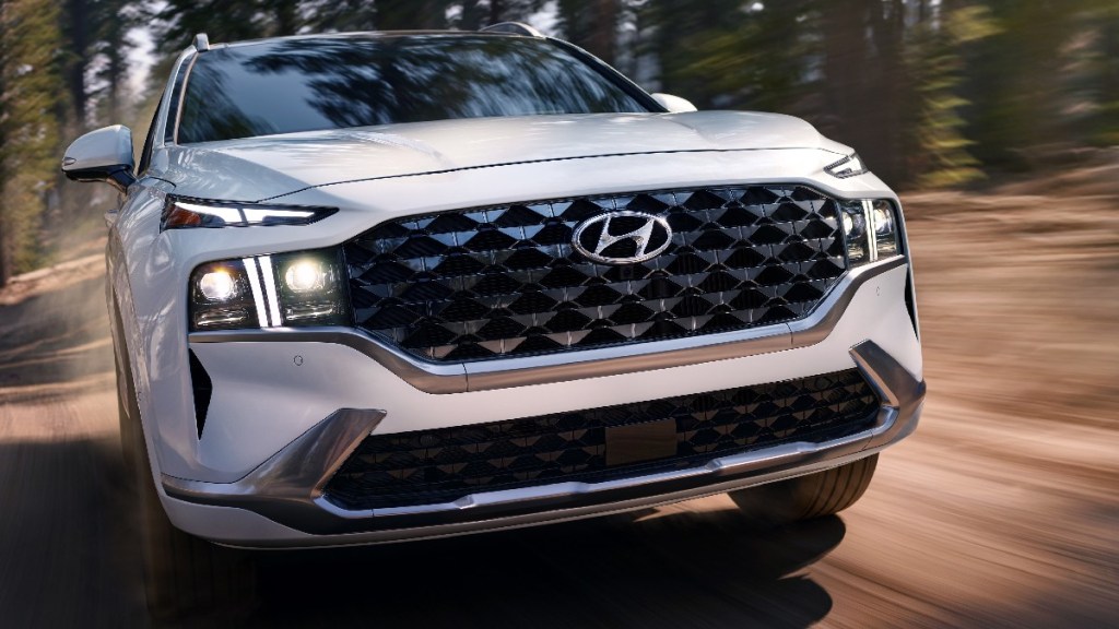Front angle view of white 2023 Hyundai Sante Fe, cheapest new midsize SUV, only one below $30,000