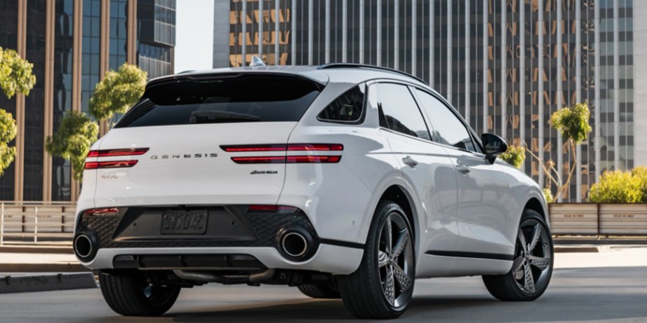 A white 2023 Genesis GV70 small luxury SUV is parked, the rear is shown., 