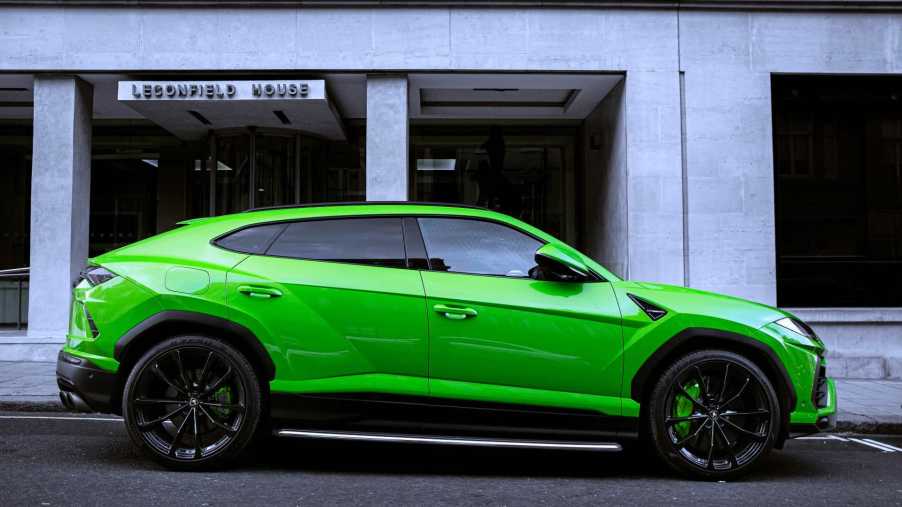 A Green Lamborghini Urus parked on a street