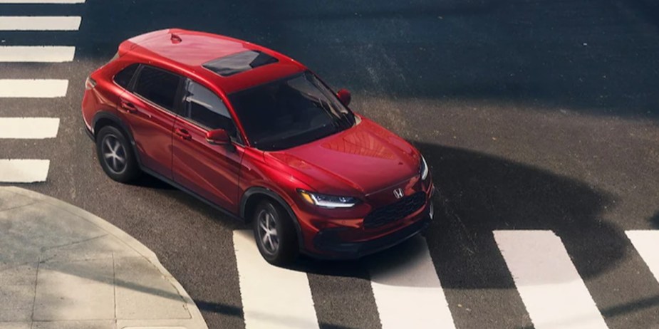 A red 2023 Honda HR-V subcompact SUV is crossing an intersection. 
