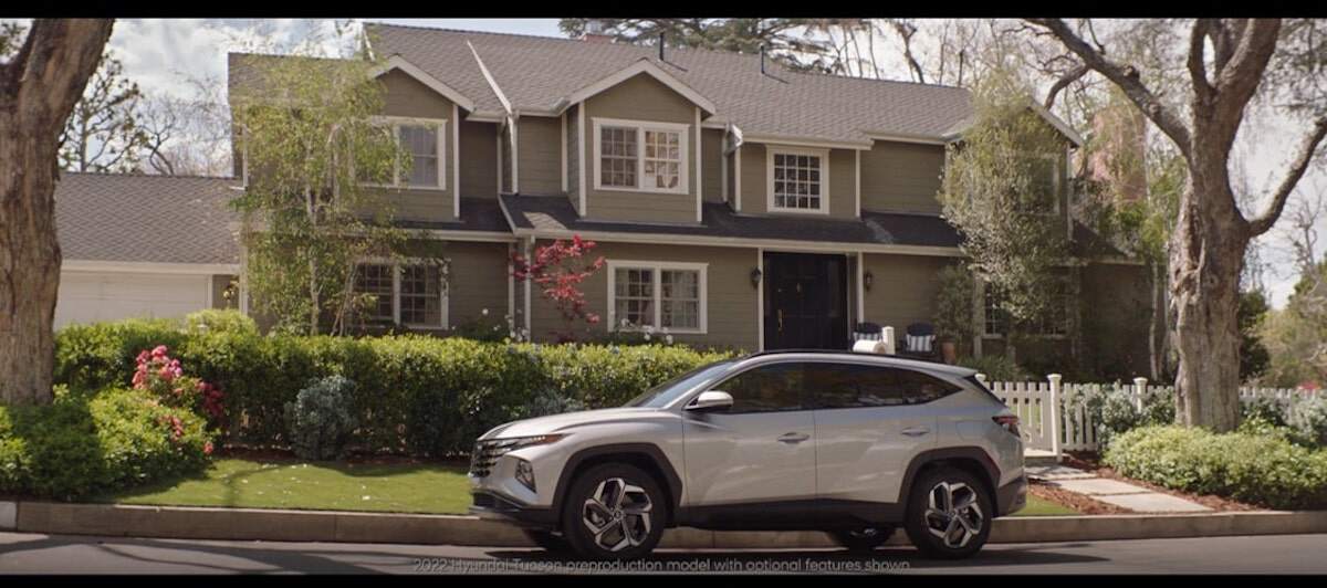A silver Hyundai parked in front of a large house as part of the Hyundai Disney partnership.