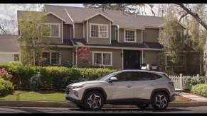 A silver Hyundai parked in front of a large house as part of the Hyundai Disney partnership.
