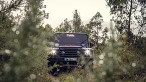 An Ineos Grenadier truck is parked in the woods.