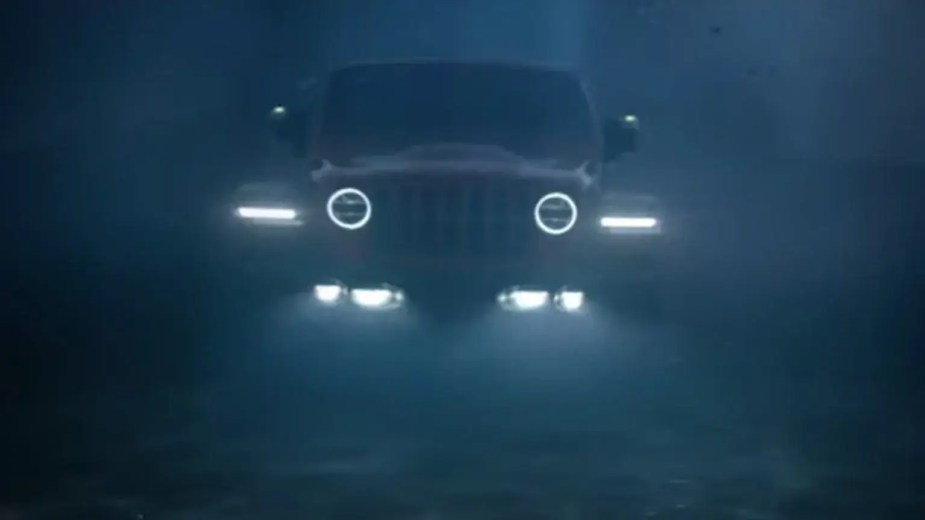 Stellantis promo photo of a modern Jeep Wrangler driving underwater, its headlights illuminating the ocean.
