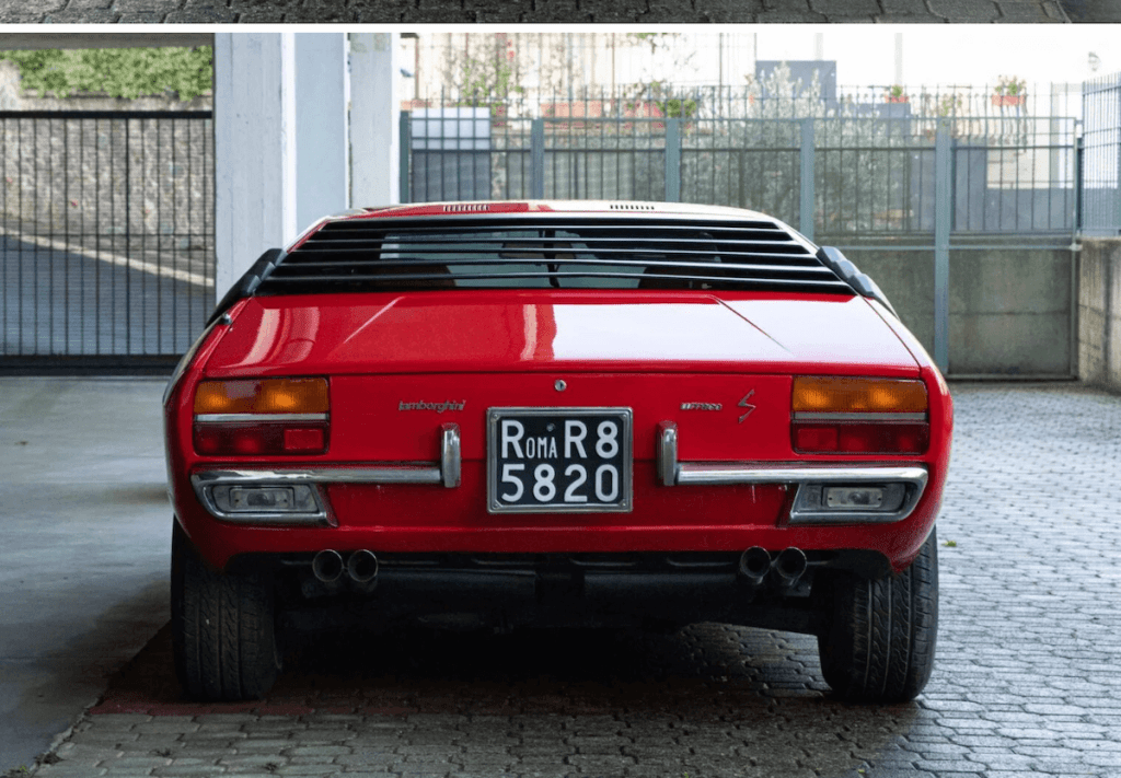 A rare red Lamborghini Urraco shor from behind.