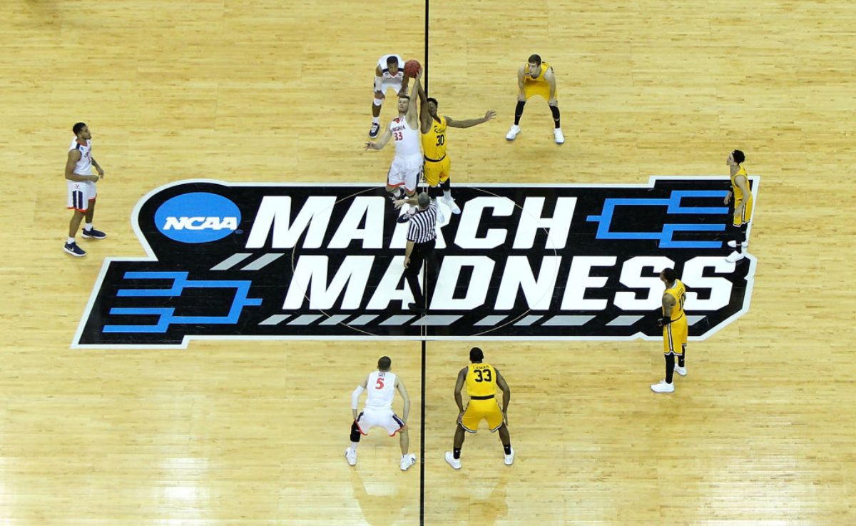 A college basketball game tipping off during the NCAA March Madness tournament.
