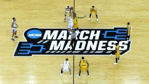 A college basketball game tipping off during the NCAA March Madness tournament.