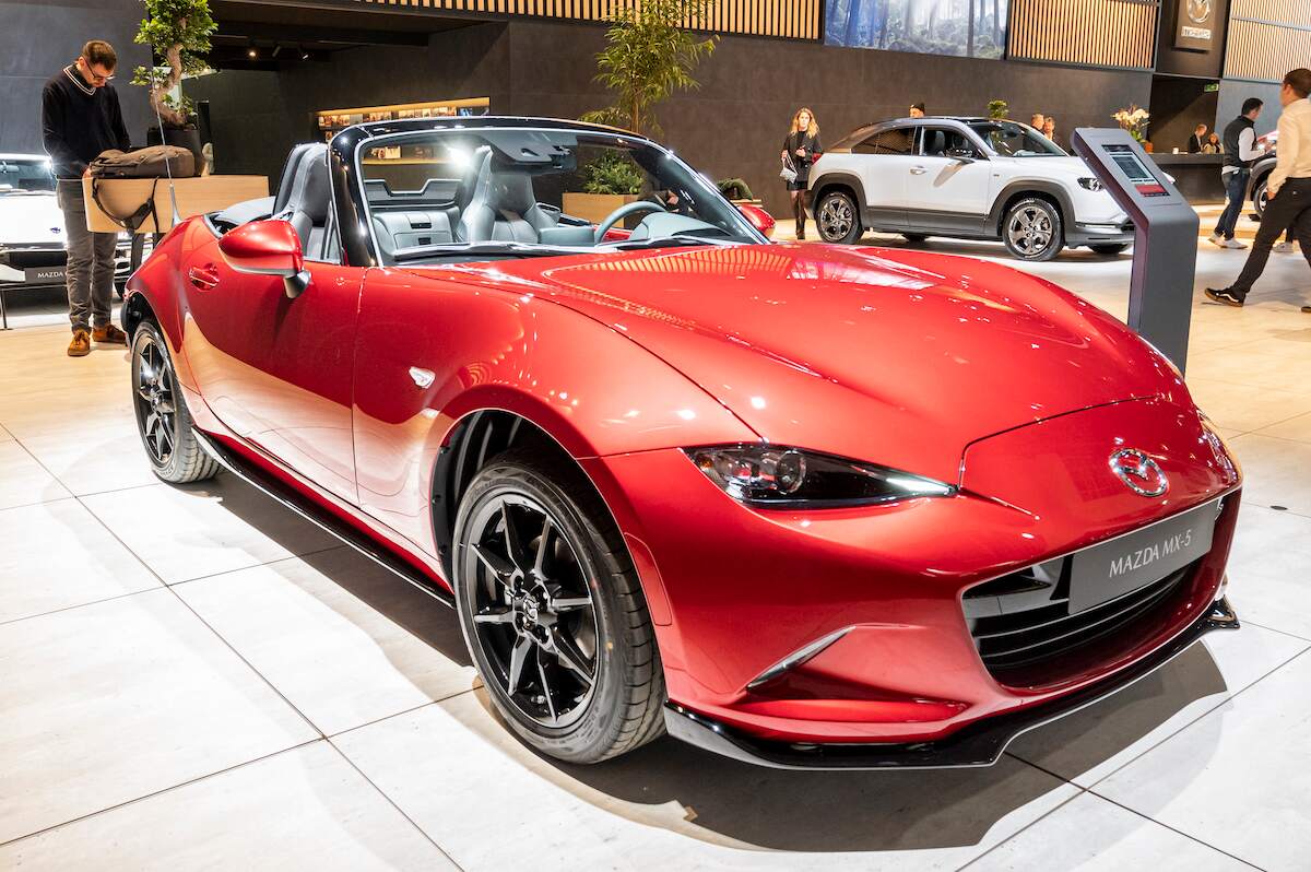 A red Mazda MX-5 coupe parked in doors.