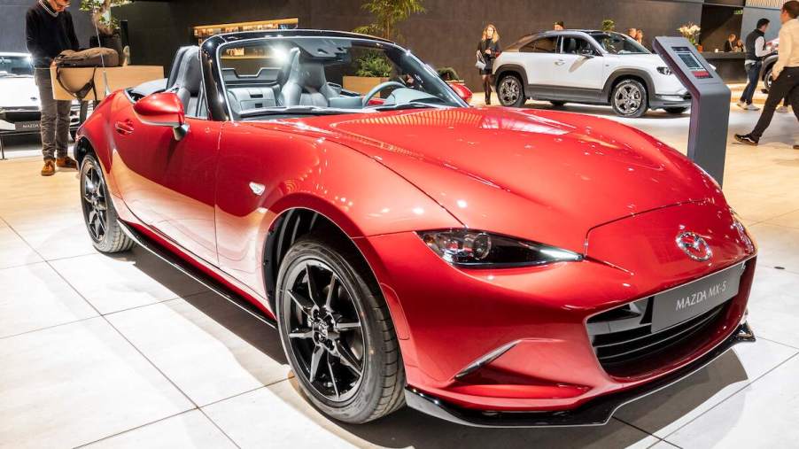 A red Mazda MX-5 coupe parked in doors.