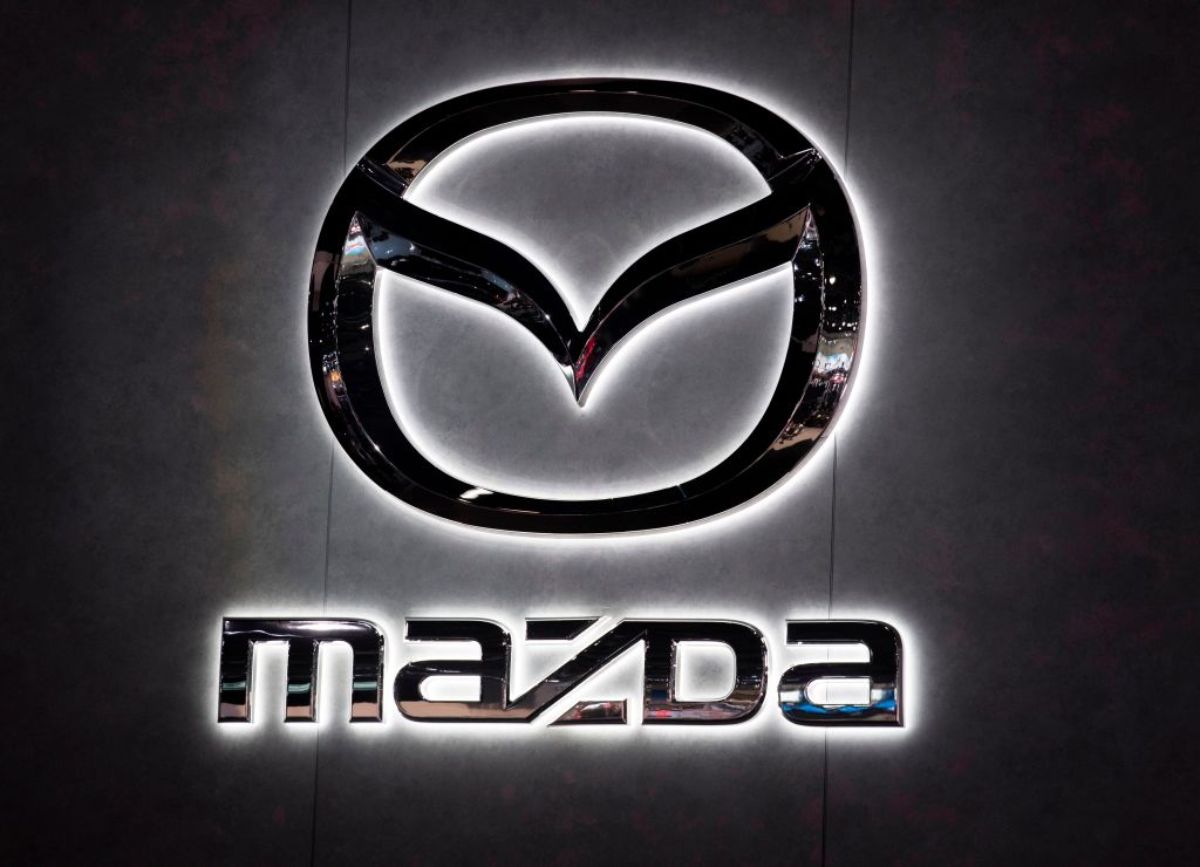 A backlight Mazda logo hanging on a wall.