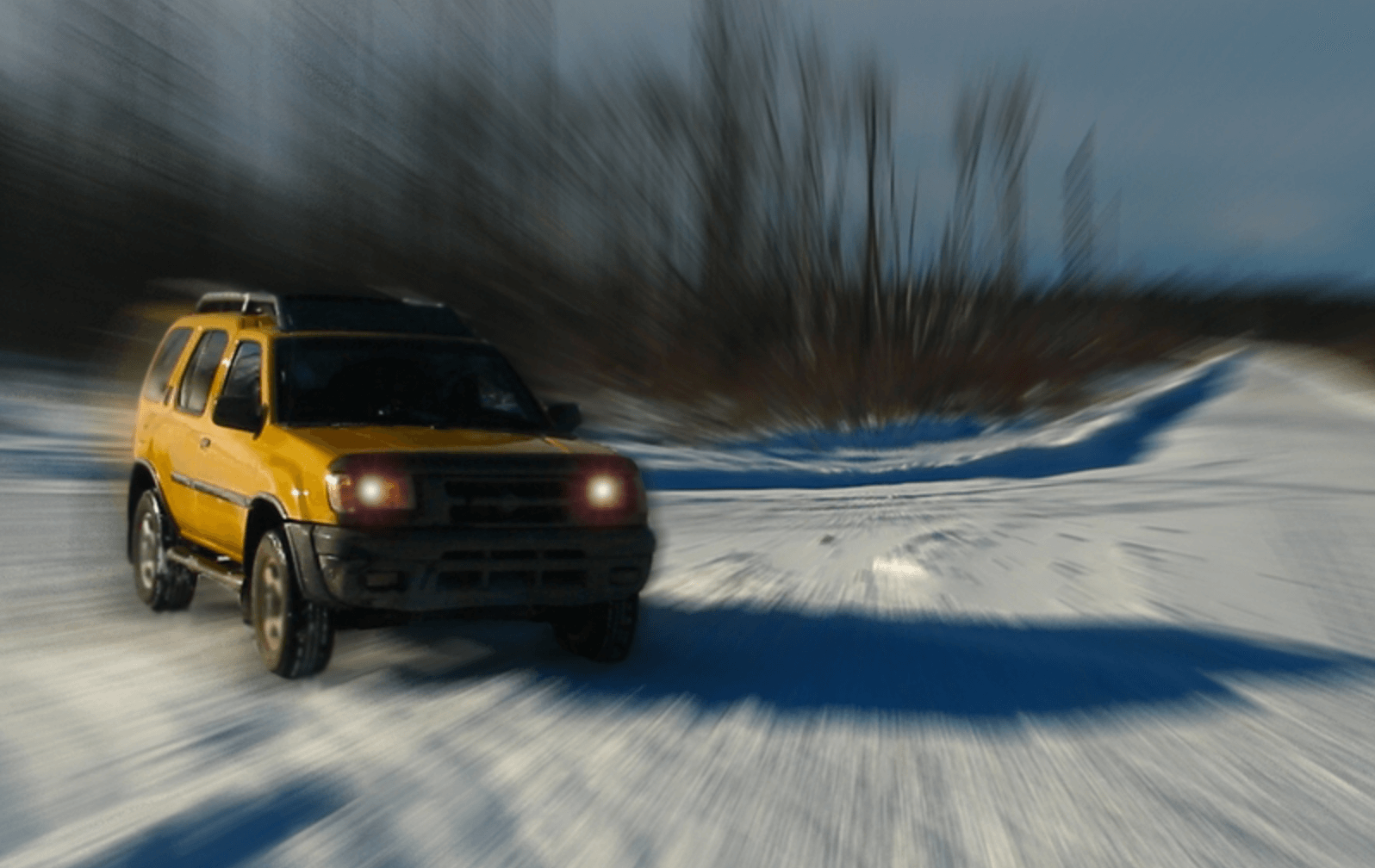 A very stylized picture of a yellow Nissan Xterra in the snow.