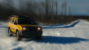 A very stylized picture of a yellow Nissan Xterra in the snow.