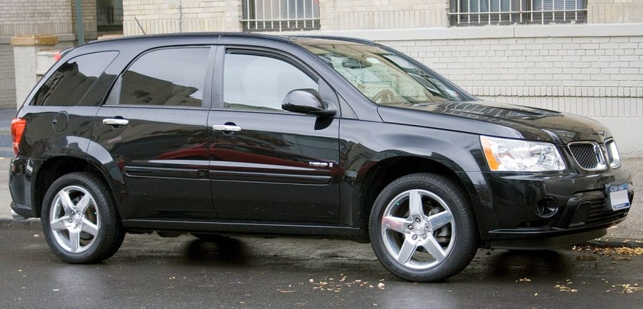 Black Pontiac Torrent GXP parked in front of a brick building