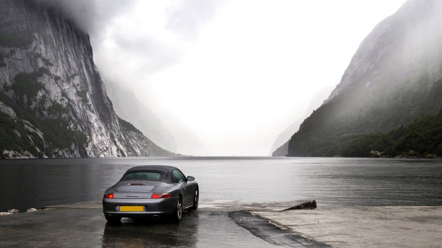 A used silver 996 Porsche 911 Convertible poses at a Norwegian Fjord.