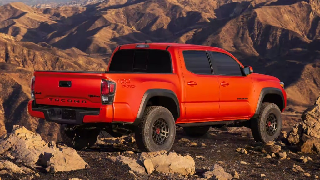 Rear angle view of orange 2023 Toyota Tacoma, most reliable midsize truck, says J.D. Power, and also best-seller