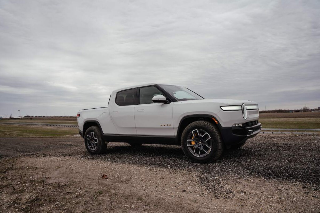 A white Rivian R1T, one of the best pickup trucks, parked in a flat desert area.
