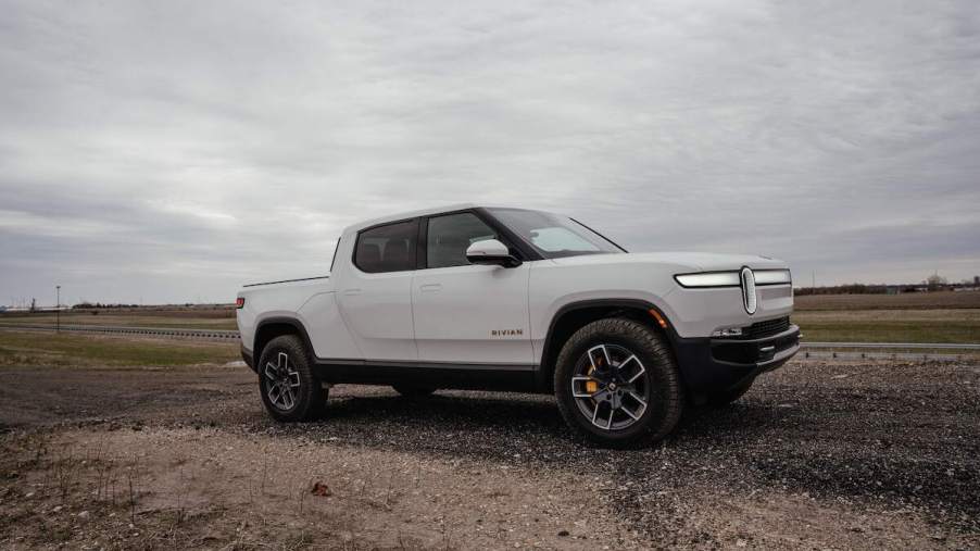 A white Rivian R1T, one of the best pickup trucks, parked in a flat desert area.