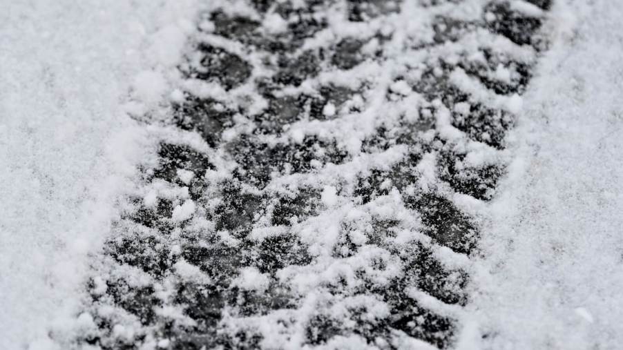 Close up of a tire print in fresh snow.