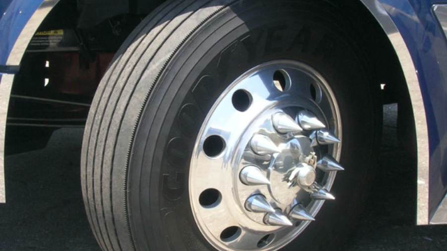 Closeup of the spiked lug nut covers on a semi truck.