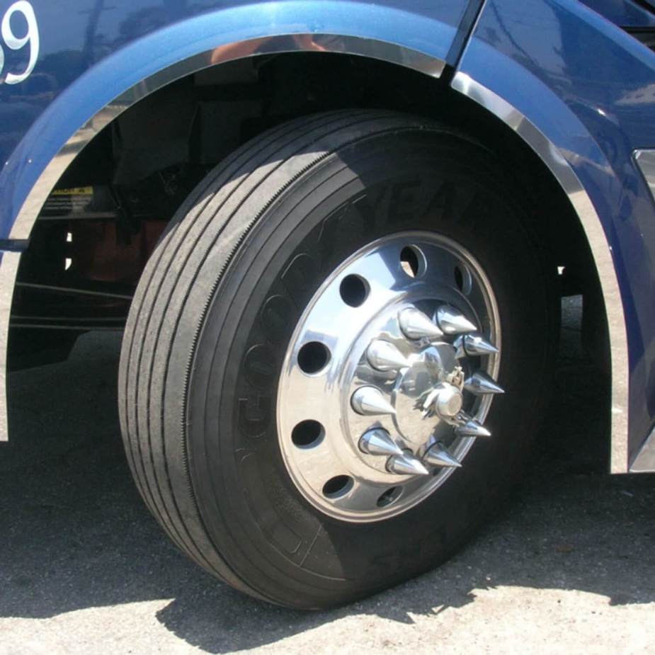 The front wheel of a semi tractor trailer truck with chromed lug nut cover spikes.
