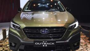 A green Subaru Outback parked indoors. The Outback is one of the best Subaru SUVs to buy.