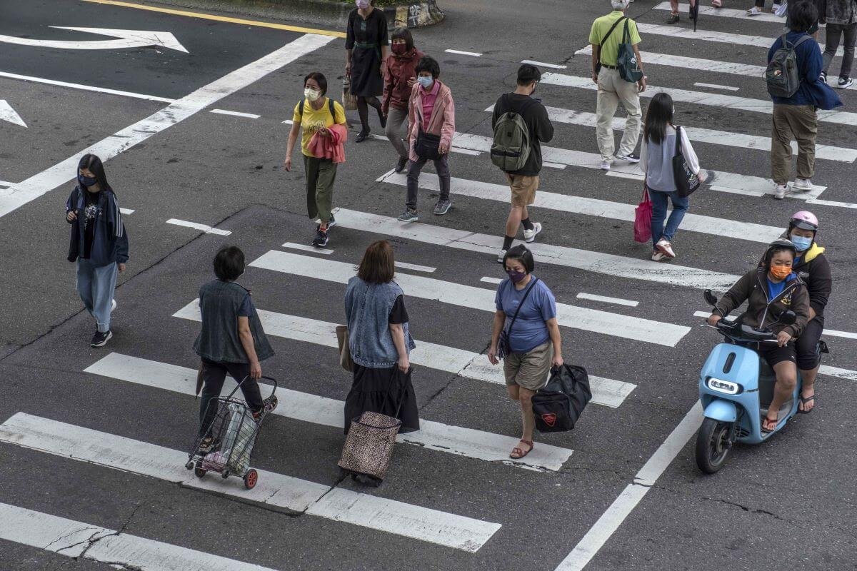 Pedestrians walking both ways on a crosswalk in Taipei, Taiwan