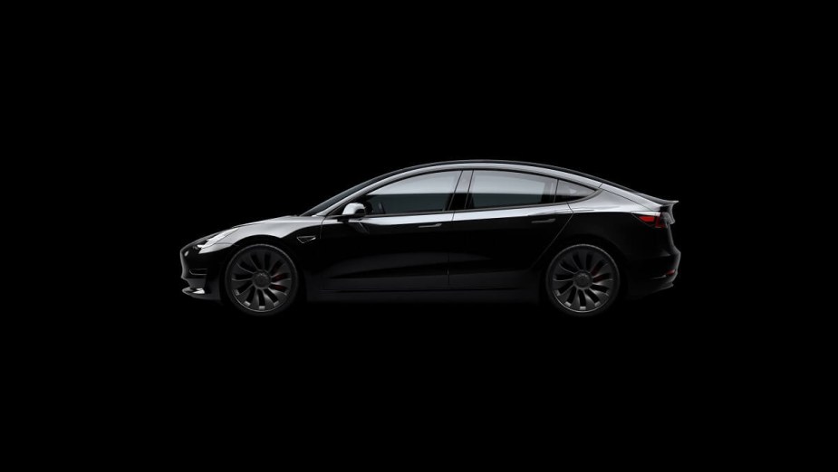 A black Tesla Model 3 EV shows off its roof and liftback rear. 