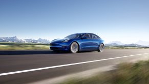 A 2022 Tesla Model 3 Long Range cruises a mountain road.