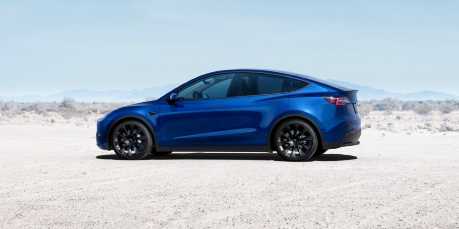 A blue 2023 Tesla Model Y small electric SUV is parked. 