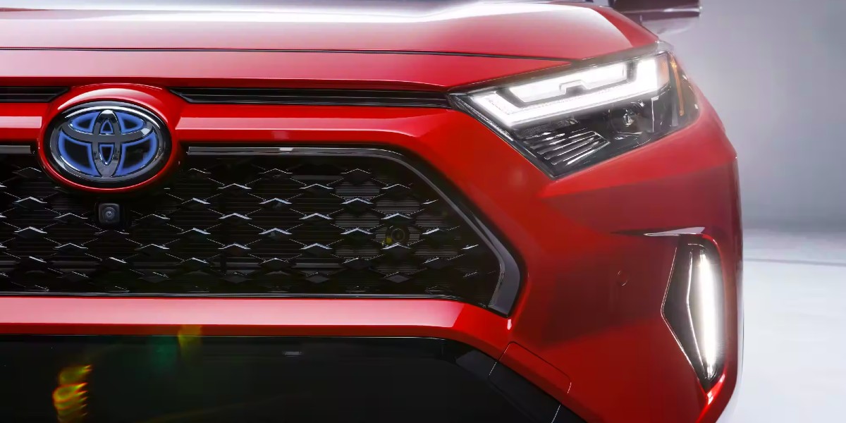 The front right side of a red Toyota RAV4 Prime.