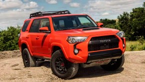 An orange 2023 Toyota 4Runner midsize SUV is parked outdoors.