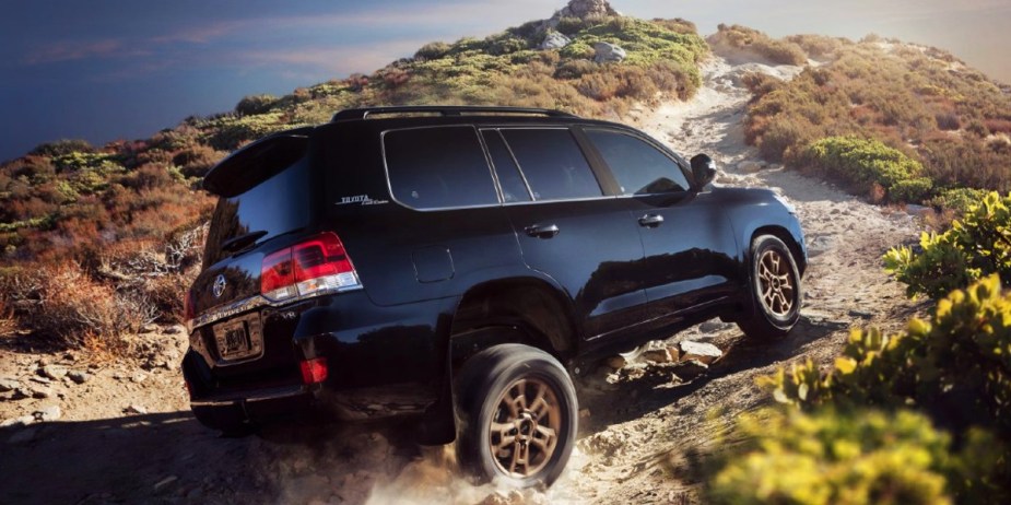 A blue Toyota Land Cruiser full-size SUV is driving off-road.