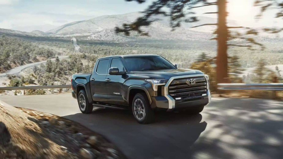 The 2023 Toyota Tundra drives on a mountain road.