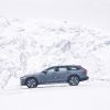 A 2023 Volvo V90 Cross Country in Thunder Grey driving near snowy mountains