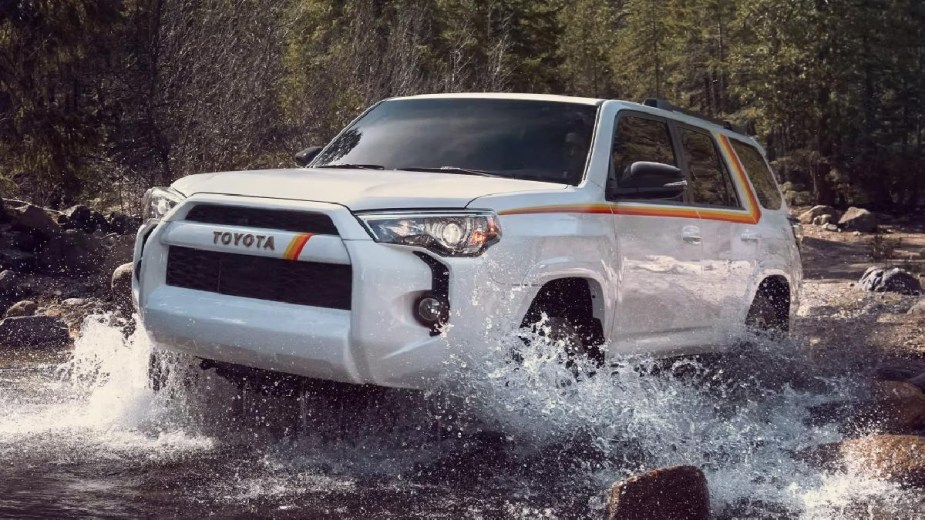 White 2023 Toyota 4Runner midsize SUV driving off-road