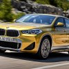 Yellow 2023 BMW X2 luxury SUV, cheapest new BMW SUV in 2023, driving on highway