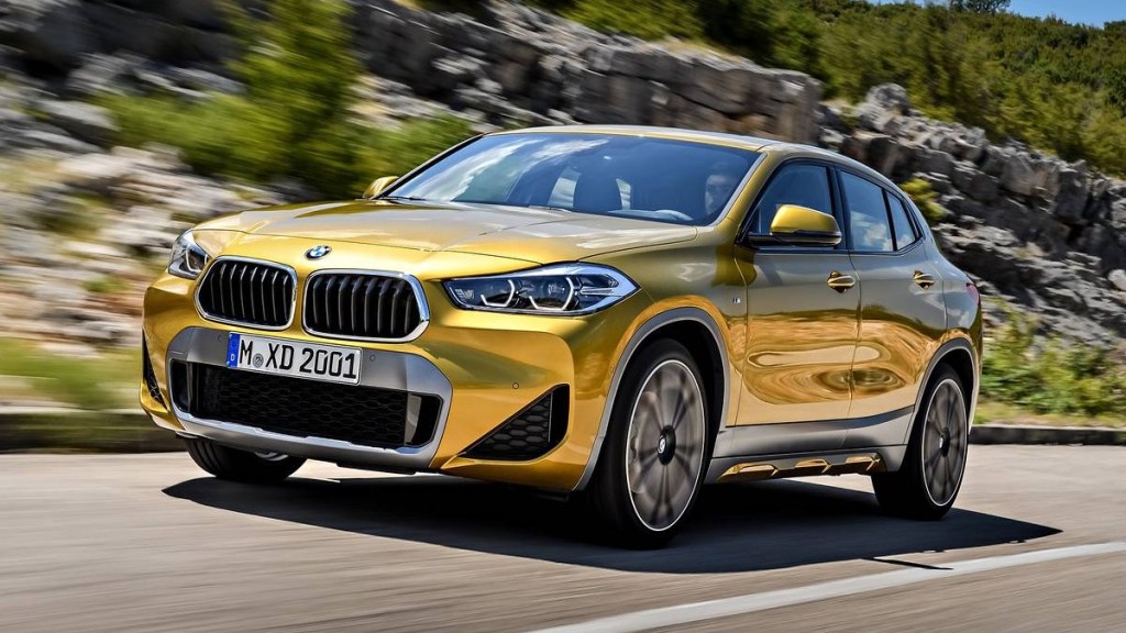 Yellow 2023 BMW X2 luxury SUV, cheapest new BMW SUV in 2023, driving on highway